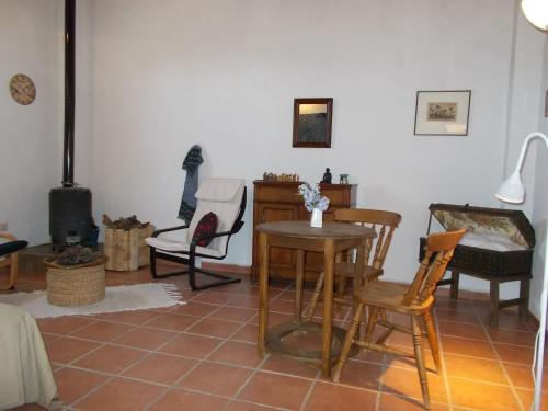 a living room with chairs and a table and a stove at Finca El Chorrillo Studio in Alcuéscar