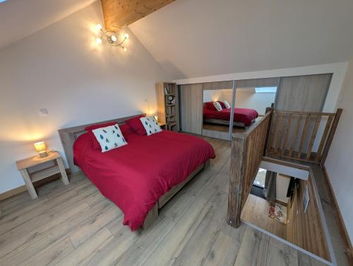 een slaapkamer met een bed met rode lakens en een spiegel bij Maisonnette cosy montagne in La Garde