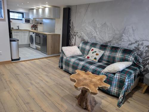 een woonkamer met een bank en een keuken bij Maisonnette cosy montagne in La Garde