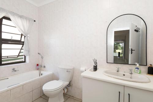 a bathroom with a toilet and a sink and a mirror at Sea Bliss in Kenton on Sea