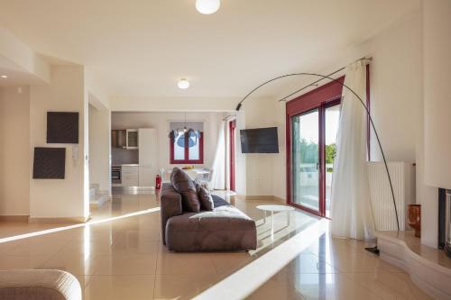 un salon avec un canapé et une table en verre dans l'établissement Ferienvilla Malvasia Mit Swimmingpool Auf Kreta, à Roúpai