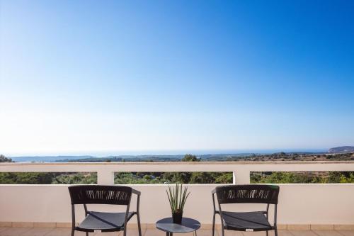 deux chaises sur un balcon avec vue sur l'océan dans l'établissement Ferienvilla Malvasia Mit Swimmingpool Auf Kreta, à Roúpai