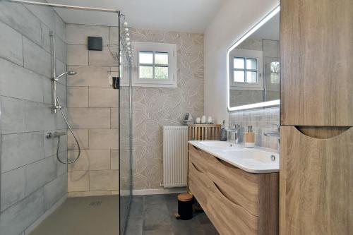 Un baño con lavabo y ducha de cristal. en Sylnat - Proche de la mer, en Les Rues