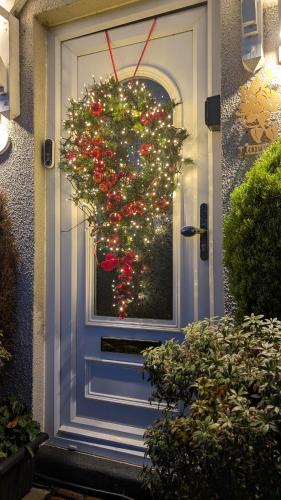 a door with a christmas wreath on it at Tropical Garden Oasis Rooms in Birmingham