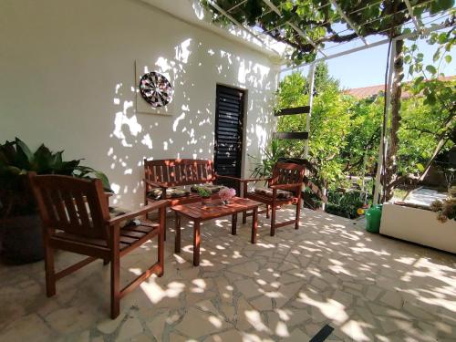 d'une terrasse avec 2 chaises et une table en bois. dans l'établissement Ferienhaus Karmen Auf Zwei Ebenen Mit Garten, à Orebić
