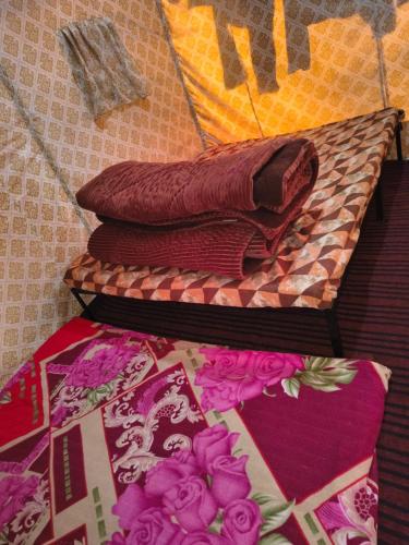 un mucchio di coperte poggiate sopra un letto di Shanti People Huts And Cafe a Kasol