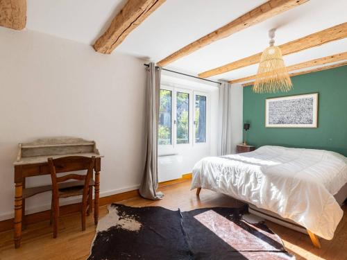 ein Schlafzimmer mit Bett, Schreibtisch und Fenster in der Unterkunft Maison de village rénovée pour 12 pers avec jardin et jacuzzi proche Loudenvielle - FR-1-695-89 in Adervielle