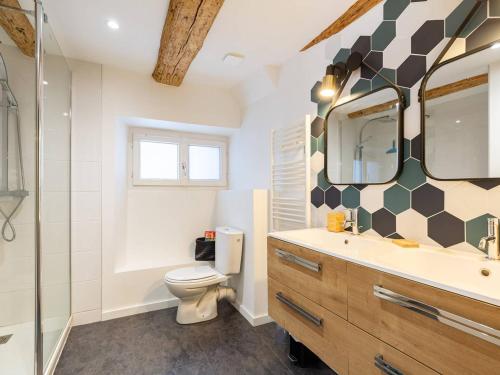 ein Badezimmer mit Toilette, Waschbecken und Spiegel in der Unterkunft Maison de village rénovée pour 12 pers avec jardin et jacuzzi proche Loudenvielle - FR-1-695-89 in Adervielle