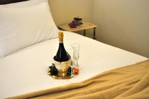 una bottiglia di vino e un bicchiere sul letto di Casa Ardizzoni a Bologna