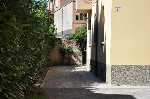 un vicolo con un edificio e una siepe di Casa Ardizzoni a Bologna