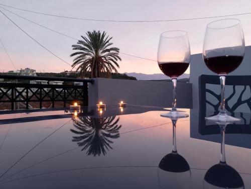 - deux verres de vin assis au-dessus d'une table dans l'établissement Emmanuel apartment, à Agia Marina