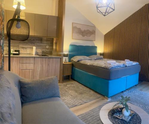 a small bedroom with a bed and a kitchen at Luma 2 in Osijek