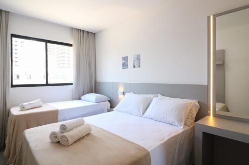 ein Hotelzimmer mit zwei Betten mit Handtüchern darauf in der Unterkunft Desfrute do melhor de Perequê a 150m do mar! CLE in Perequê