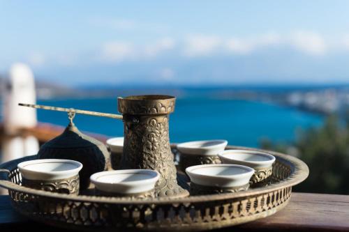 a tray with tea cups and a vase on a table at Leonidas Traditionelles Kretisches Haus Mit Meerblick in Elounda