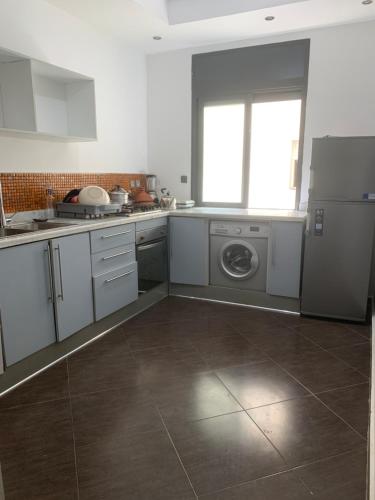 a kitchen with a refrigerator and a washing machine at Appart bacha in Kenitra