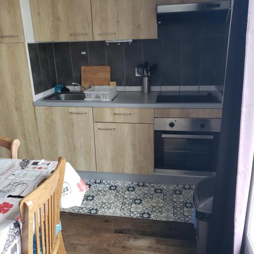 a small kitchen with a sink and a stove at Chez SamB in Lussac-les-Châteaux