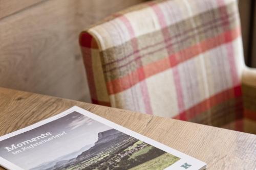 a magazine sitting on a table next to a couch at Hotel Andreas Hofer in Kufstein