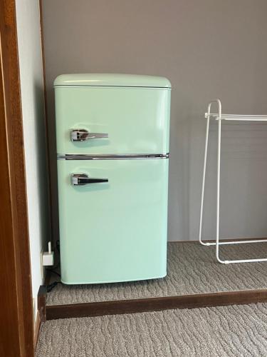 an old refrigerator in a corner of a room at ゲストハウス椙乃家 in Matsukawa