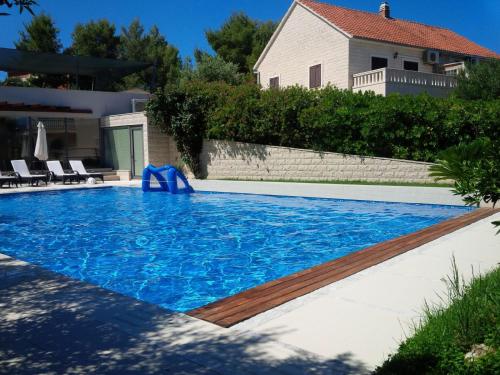 una piscina con acqua blu davanti a una casa di Helle Studio Ferienwohnung Mit Sonnenbalkon a Splitska