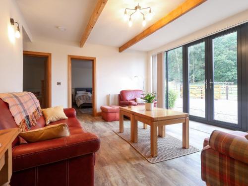 a living room with a couch and a table at Sumner Lodge in Kyre Magna