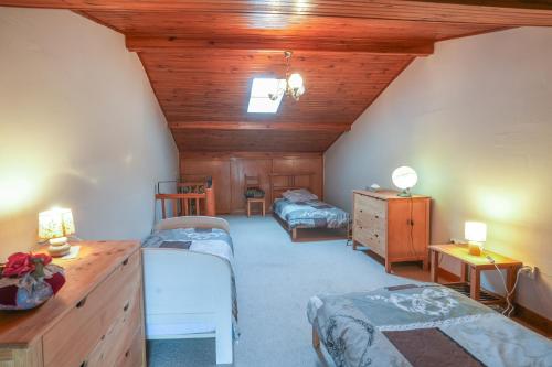 Cette chambre mansardée comprend deux lits et un plafond en bois. dans l'établissement La Maison de Julie - Proche Sites Historique, à Septfonds