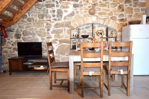a dining room with a table and a stone wall at Ferienhaus In Dobropoljana Mit Privatem Pool in Dobropoljana