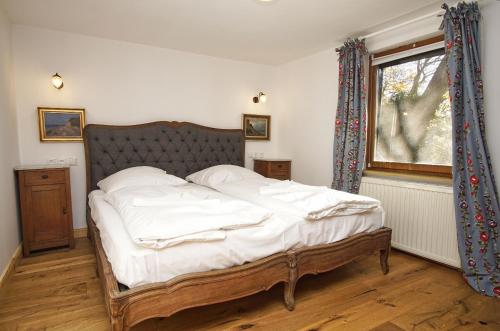 a bedroom with a bed with white sheets and a window at Landhaus Lietzow Haus Cottage Garden in Lietzow
