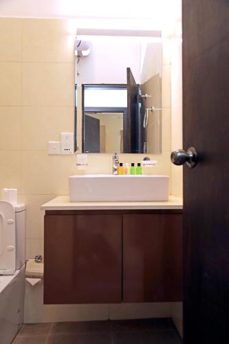 a bathroom with a white sink and a mirror at Ocean Breeze Negombo by Wavelet360 in Negombo