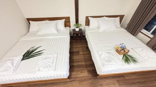 deux lits côte à côte dans une pièce dans l'établissement Cha homestay, à Phanom