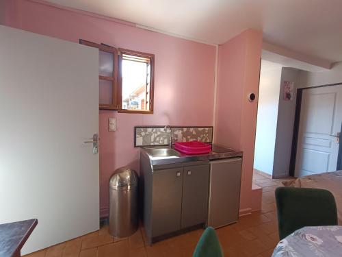 Una cocina con paredes rosas y una mesa en una habitación. en Gite 5 Pers proche Wimereux, en Belle-et-Houllefort