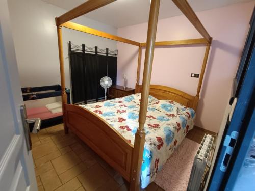 un dormitorio con una cama con dosel en Gite 5 Pers proche Wimereux, en Belle-et-Houllefort