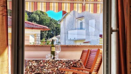 une table et une chaise sur un balcon avec une fenêtre dans l'établissement Große Wohnung In Palit Mit Privatem Balkon, à Palit