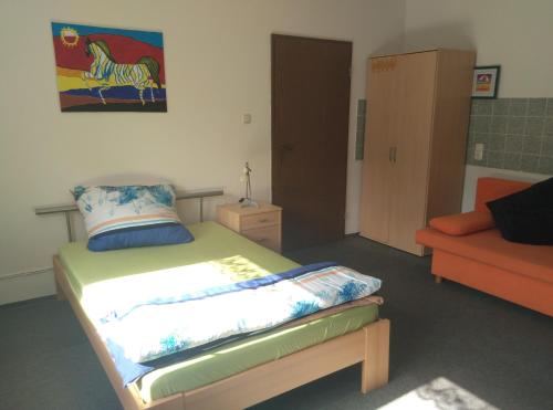 ein Schlafzimmer mit einem Bett und einem orangefarbenen Sofa in der Unterkunft Longmen Mountain Villa in Egloffstein