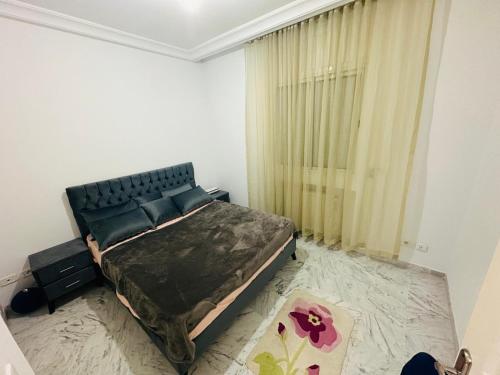 ein Schlafzimmer mit einem großen Bett und einem Fenster in der Unterkunft Eden Cozy Airport in El Aouina Station