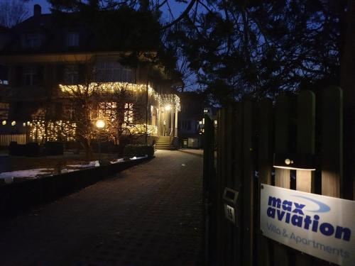 Un misterioso cartel de activación en una valla frente a un edificio en Max Aviation Villa & Apartments, en Berna