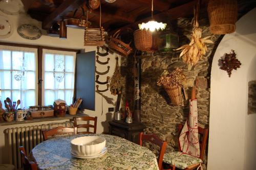 a dining room with a table and a stone wall at Le Primule in Piedilago