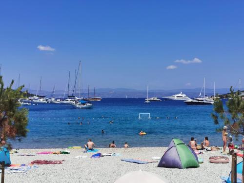 a group of people on a beach with boats in the water at Apartment Bella Mit Balkon Und Terrasse In Necujam in Nečujam