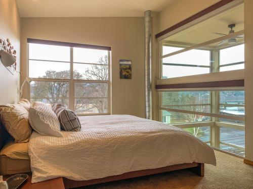 une chambre avec un lit et deux grandes fenêtres dans l'établissement Urban Loft 30 day minimum, à Hood River