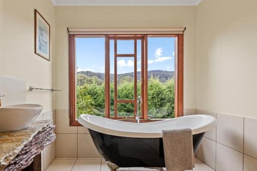 ein Badezimmer mit Badewanne und großem Fenster in der Unterkunft Gilderoy Valley Views- Farm house in Gladysdale