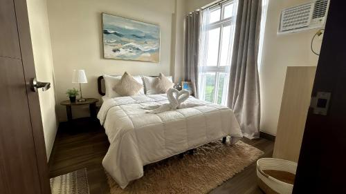 a bedroom with a white bed with a bow on it at Ocean Verde Suite Boracay in Boracay