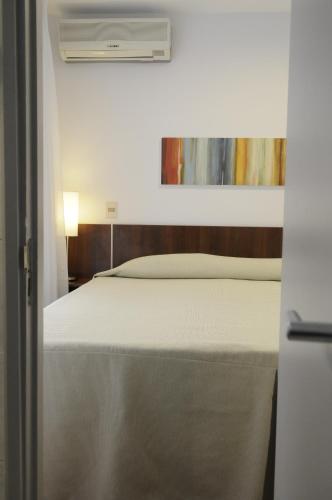 a bedroom with a bed with a white mattress at Hotel California in Montevideo