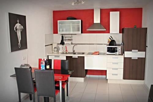 a kitchen with a table and a red and white kitchen at Casa Romeo Mit Kaminofen Und Sonnenterrasse in Guía de Isora