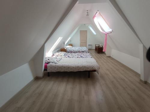 1 dormitorio en el ático con cama y ventana en Gite 15 pers maxi proche Wimereux, en Belle-et-Houllefort
