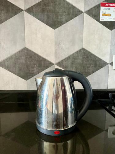 ein Teekessel aus Metall auf einem Tisch in der Unterkunft Cozy Casa de Darco Studio Apt BSD W Pool & Gym in Kedeper