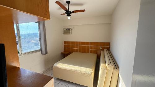 Cette petite chambre comprend un lit et un ventilateur de plafond. dans l'établissement Apartamentos Aquarius Flat, à Caldas Novas