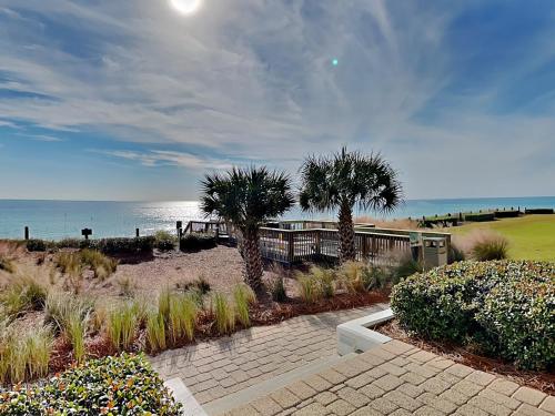 a house with palm trees next to the beach at Adagio #105B in Santa Rosa Beach