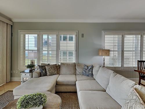 a living room with a large couch and windows at Adagio #105B in Santa Rosa Beach