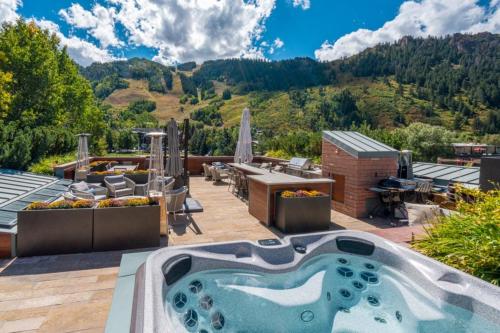 Un jacuzzi en un patio con vistas a la montaña. en Aspen The Mother Lode, en Aspen