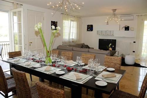 - une salle à manger avec une table, des chaises et un canapé dans l'établissement Villa Panoramica, à Pozzolengo