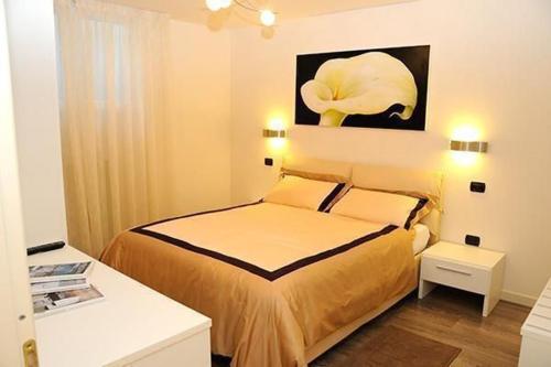 une chambre avec un lit et un tableau au mur dans l'établissement Villa Panoramica, à Pozzolengo